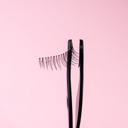 Close-up of Ardell Magnetic Lash held in applicator, showing dual magnetic strip for precise placement.