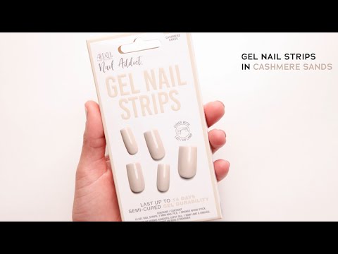 Hand holding Ardell Nail Addict Gel Nail Strips in Cashmere Sands, a semi-cured nude shade set for up to 14 days of wear.